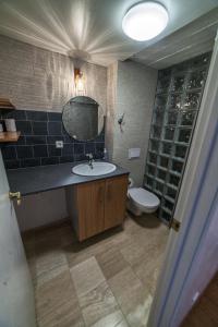 a bathroom with a toilet, sink, and bathtub at Sólheimar Studio Apartment in Ísafjörður