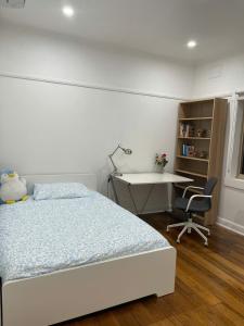 a bedroom with a bed and a desk and a table at Oakleigh South Charm in Oakleigh South