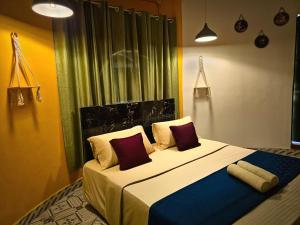 蓬蒂切里Aura Breeze的卧室里有一张大床，配有红色枕头