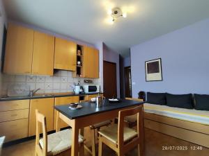 a kitchen with a table and chairs in a room at Il Faro - Coazze in Coazze