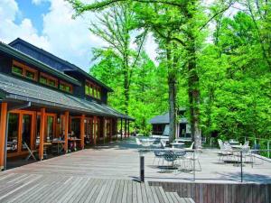 a patio with tables and chairs in front of a building at Le Repos軽井沢 in Karuizawa