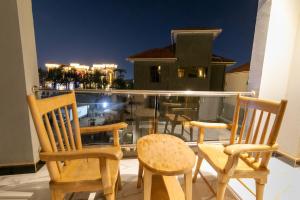 a group of chairs sitting on a balcony at night at Elysian lux home in Kampala