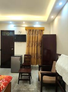 a living room with a bed and a couch and a table at Hotel Nagar in Khulna +3 photos