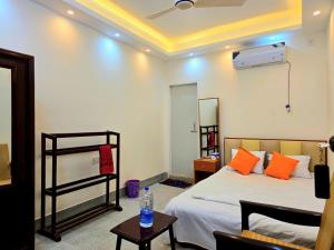 a bedroom with a bed with orange pillows at Hotel Nagar in Khulna