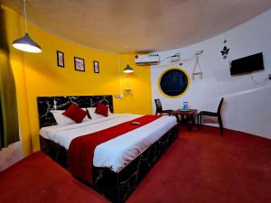 a bedroom with a large bed in a room with yellow walls at Aura Breeze in Pondicherry