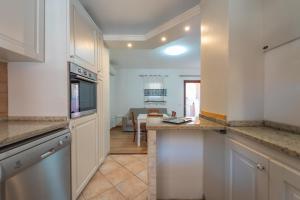 a kitchen with white cabinets and a counter top at casa laura in Olbia
