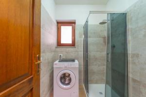 a bathroom with a washing machine and a shower at casa laura in Olbia