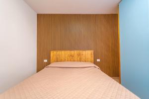 a bedroom with a bed and a striped wall at casa laura in Olbia