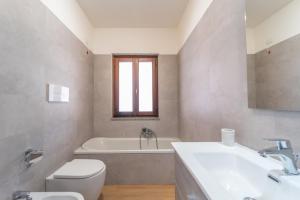 a bathroom with a tub and a toilet and a sink at casa laura in Olbia +13 photos