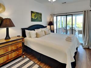 a bedroom with a large bed and a table with a lamp at Weston Beach Place in Tybee Island