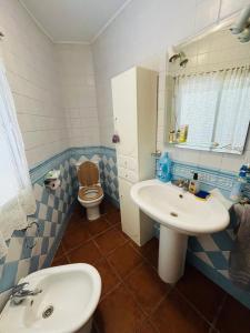 a blue and white bathroom with a sink and a toilet at La Casa De Los Gatetes in Dúrcal