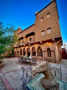 a building with a statue of a horse in front of it at Hotel Carrefour des Nomades in Mhamid