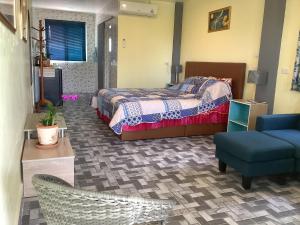Un dormitorio con una cama, una silla y un sofá. en CC Homestay, en Surin