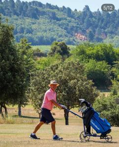 un uomo che tira un passeggino blu di Point de départ de randonnées pédestres ou vélo dans le Luberon ad Apt