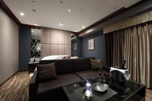 een woonkamer met een bank en een bed bij Hotel Valentine Chiryu in Chiryu +33 foto's