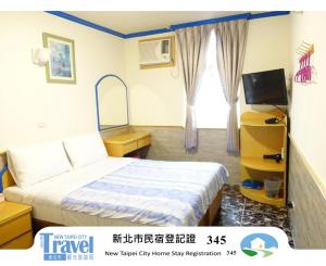 a hotel room with a bed and a television at Fulong Haido Inn in Gongliao