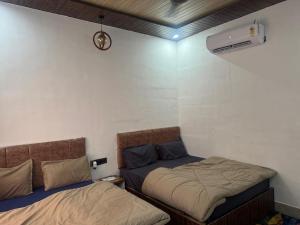 Un dormitorio con dos camas y un reloj en la pared. en Win Retreat & Cottage Rishikesh, en Rishīkesh