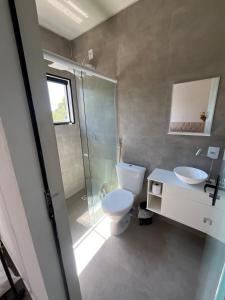 a bathroom with a toilet and a sink and a shower at Lofts in the heart of Rosa in Imbituba