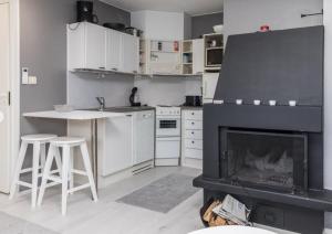 a living room with a fireplace and a kitchen at Tahko North Lodge B 5 in Kuopio +10 photos