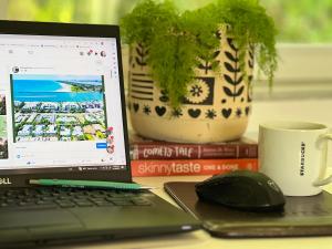 a laptop computer sitting on top of a desk with a coffee mug at Fernando Flats in Palm Beach Shores