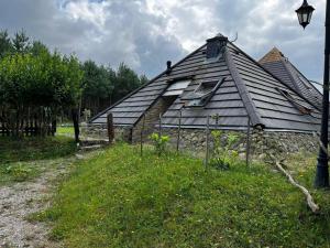 an old house with a roof and a street light at Kaszubskie Piramidy in Borzytuchom