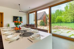 a dining room with a white table and a large window at Willa Izerska z ogrodem by Royal Aparts in Pobiedna