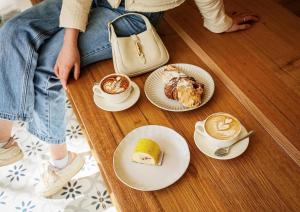 een persoon die op de grond zit met borden eten en kopjes koffie bij Cosy Footscray Studio - 2 Guests in Melbourne