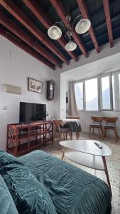 a living room with a couch and a table at El ático de los mosaicos in Cádiz