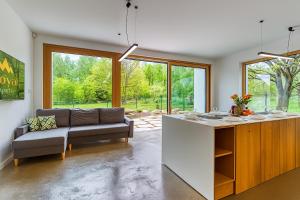 a living room with a couch and a kitchen at Willa Izerska z ogrodem by Royal Aparts in Pobiedna