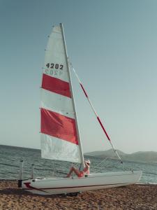 a person sitting on a sail boat on the beach at Flow Datca Surf & Beach Hotel in Datca