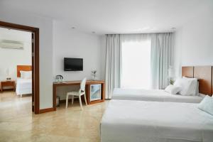 a hotel room with two beds and a desk at Flow Datca Surf & Beach Hotel in Datca +99 photos