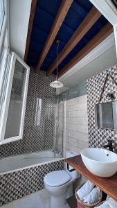 a bathroom with a sink and a toilet and a tub at El ático de los mosaicos in Cádiz
