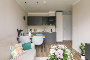 un soggiorno e una cucina con un divano e un tavolo di Zeitraum Raclawicka a Cracovia Altre 7 foto