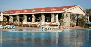 a resort with a swimming pool in front of a building at Flow Datca Surf & Beach Hotel in Datca