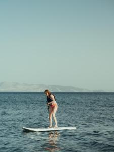 a woman in a bikini on a surfboard in the water at Flow Datca Surf & Beach Hotel in Datca