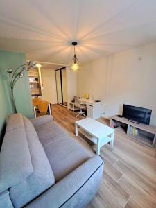 una sala de estar con un sofá y una mesa en Bel appartement au calme avec parking, en Lyon