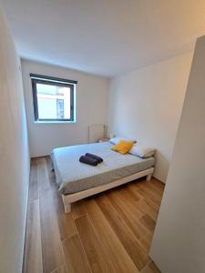un dormitorio con una cama y una ventana en Bel appartement au calme avec parking, en Lyon