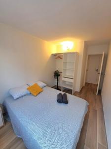 Un dormitorio con una cama con dos zapatos encima. en Bel appartement au calme avec parking, en Lyon