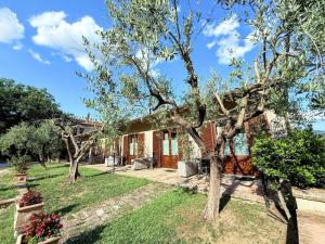 una casa con árboles frente a un patio en Luxury Villa in Spello, Private Pool, Spa, Restaurant, sleeps 54 inc 18 children, en Spello