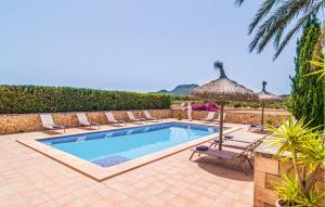 a swimming pool with chairs and an umbrella at Cas Cuni in Felanitx