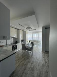 a kitchen and dining room with a table and chairs at Apartments in VODOGRAY Residential Complex Краєвид і охайність захоплюють дух! in Chernivtsi
