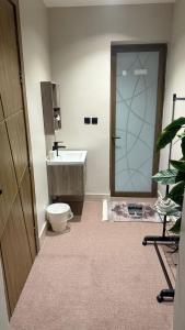 a bathroom with a toilet and a sink and a shower at استديو الهدوء in Dammam