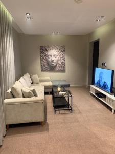 a living room with a couch and a flat screen tv at استديو الهدوء in Dammam +11 photos