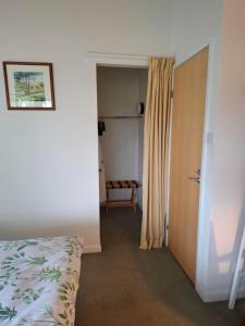a bedroom with a bed and a door with a window at Aquila Retreats in Comrie