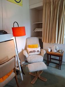 a living room with a chair and a lamp at Aquila Retreats in Comrie