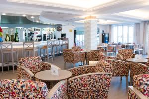 restauracja z krzesłami i stołami oraz bar w obiekcie Hotel Voramar w Cala Millor
