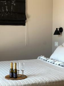 three bottles and glasses on a tray on a bed at Sea You Soon & Spa 2 in Methana +32 photos