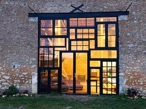 a window of a building with the sun shining through at Ferme Goodwill in Agonac