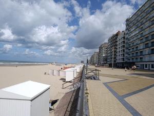 a beach with a row of beach chairs and buildings at Zeedijk 237 Middelkerke in Middelkerke