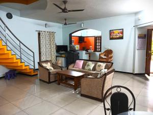 a living room with a couch and chairs and a table at Helios Villa in Auroville